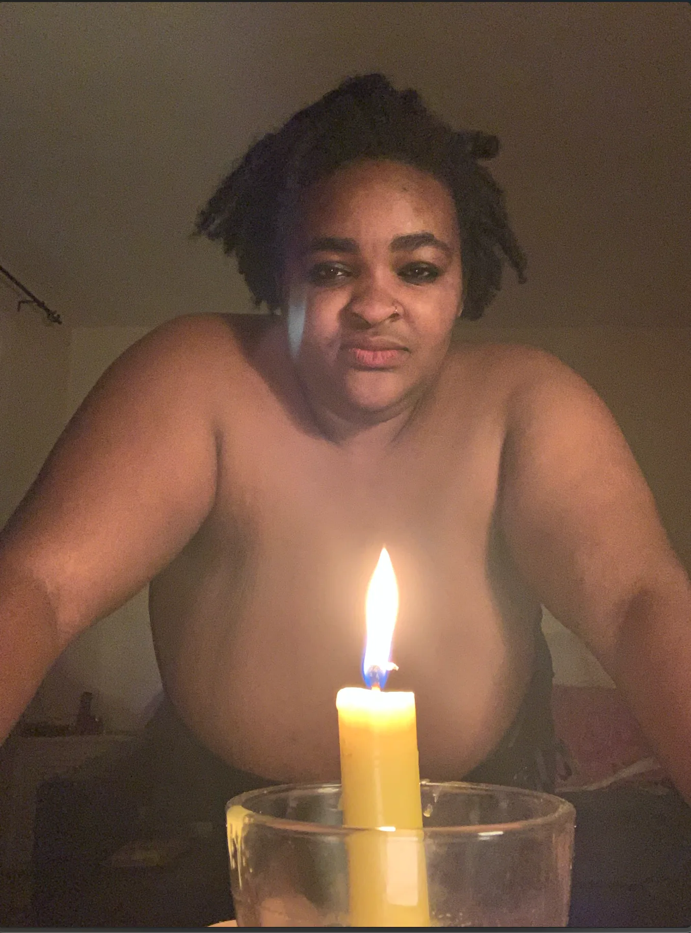 Demoness Uté framed by a lit ritual candle